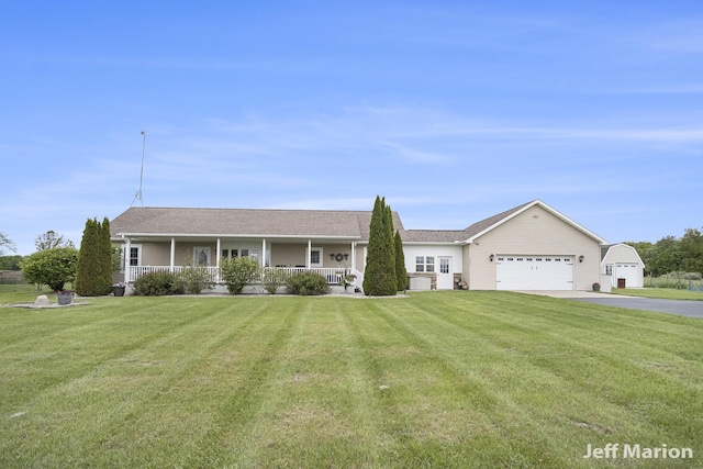 2057 Nickleplate Rd, Ionia, MI 48846 - ranch-style house featuring covered porch, asphalt driveway, a garage, and a front yard