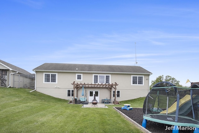 2057 Nickleplate Rd, Ionia, MI 48846 - back of property featuring a trampoline, a pergola, a patio, a yard, and an outdoor fire pit