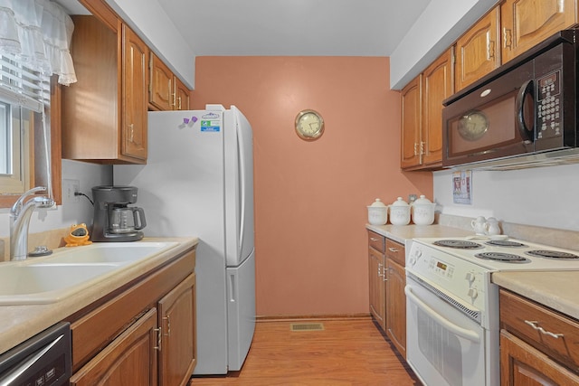 3272 Cambridge St SE, Grand Rapids, MI 49512 - kitchen featuring white appliances, a sink, light countertops, and brown cabinetry