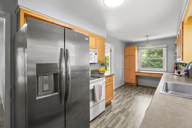 313 W Kilgore Rd, Portage, MI 49002 - kitchen featuring white appliances, a sink, light wood-type flooring, hanging light fixtures, and light countertops