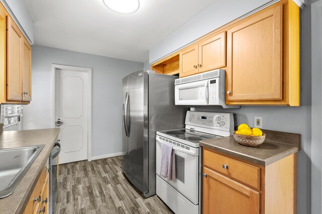 313 W Kilgore Rd, Portage, MI 49002 - kitchen with appliances with stainless steel finishes, light wood-type flooring, baseboards, dark countertops, and a sink