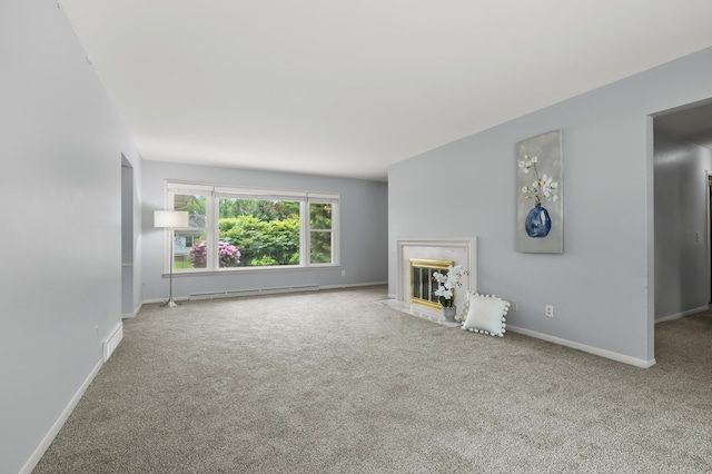 313 W Kilgore Rd, Portage, MI 49002 - unfurnished living room featuring baseboard heating, carpet, baseboards, and a fireplace with flush hearth