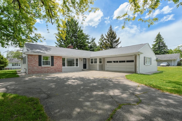 313 W Kilgore Rd, Portage, MI 49002 - ranch-style home with an attached garage, brick siding, asphalt driveway, a chimney, and a front lawn