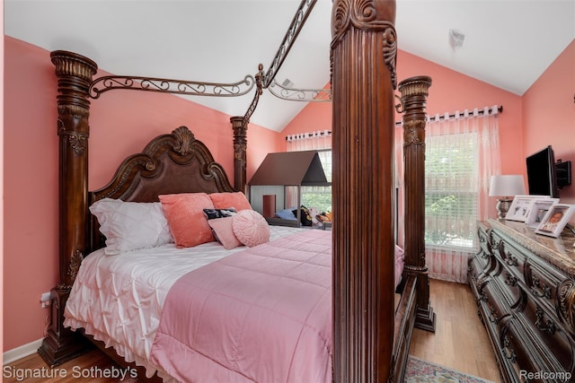 340 N Wixom Rd, Wixom, MI 48393 - bedroom featuring lofted ceiling, multiple windows, and wood finished floors