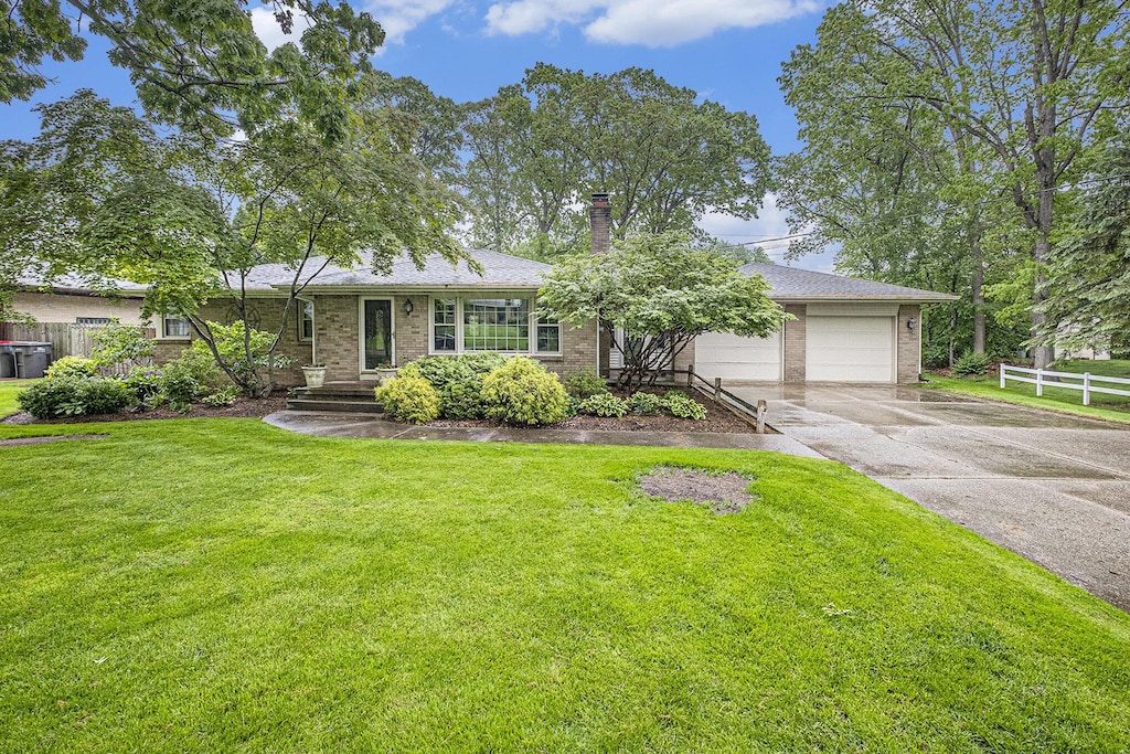 2446 Bristolwood Dr NW, Grand Rapids, MI 49544 - single story home with driveway, a garage, brick siding, and a chimney