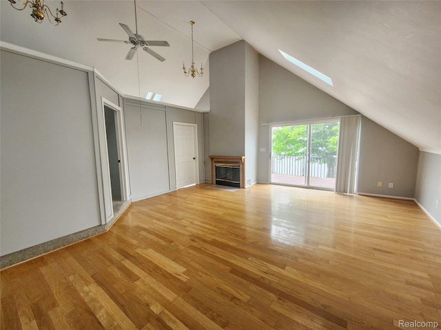 4390 Cass Elizabeth Rd, Waterford, MI 48328 - unfurnished living room featuring a chandelier, ceiling fan, a glass covered fireplace, a skylight, and wood finished floors