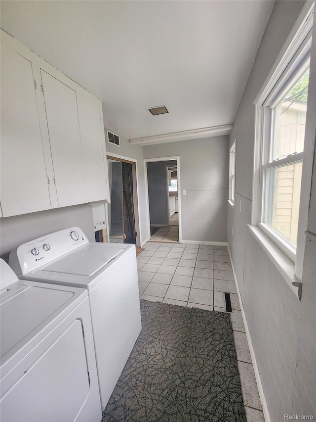 4390 Cass Elizabeth Rd, Waterford, MI 48328 - laundry area featuring washing machine and clothes dryer, light tile patterned floors, healthy amount of natural light, and cabinet space