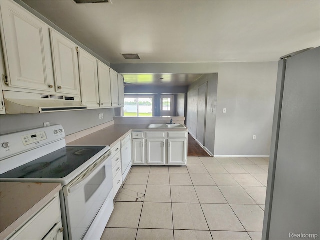 4390 Cass Elizabeth Rd, Waterford, MI 48328 - kitchen with white range with electric stovetop, under cabinet range hood, a peninsula, light tile patterned flooring, and white cabinetry