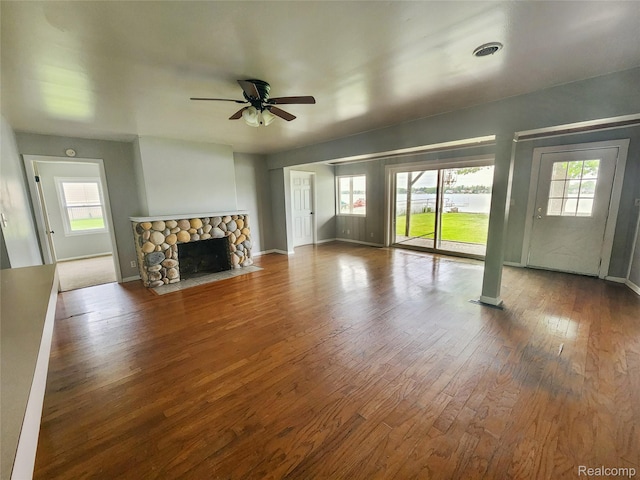 4390 Cass Elizabeth Rd, Waterford, MI 48328 - unfurnished living room with hardwood / wood-style flooring, plenty of natural light, a ceiling fan, and a stone fireplace