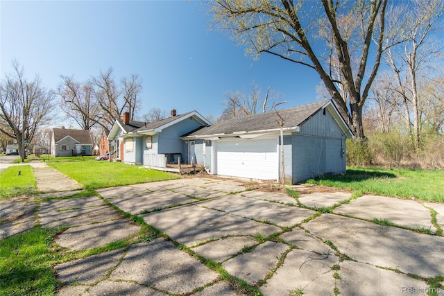 600 Alameda St, Highland Park, MI 48203 - view of front facade featuring a garage, a front lawn, and concrete driveway