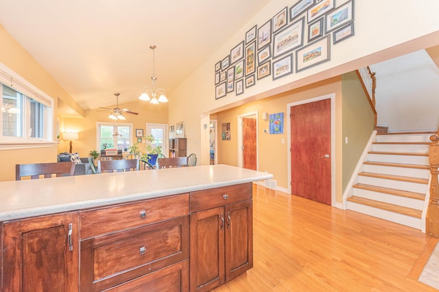 500 Little Lake Dr # 1, Ann Arbor, MI 48103 - kitchen with light wood-style flooring, ceiling fan, light countertops, decorative light fixtures, and high vaulted ceiling
