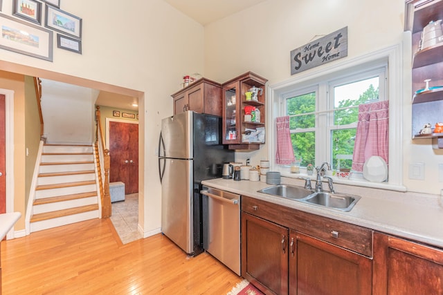 500 Little Lake Dr # 1, Ann Arbor, MI 48103 - kitchen featuring appliances with stainless steel finishes, a sink, open shelves, light countertops, and light wood finished floors
