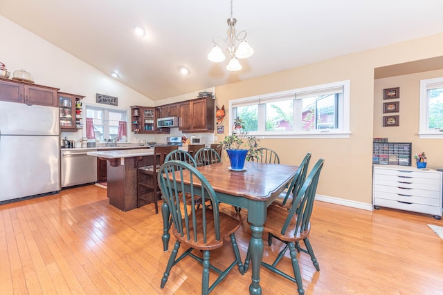 500 Little Lake Dr # 1, Ann Arbor, MI 48103 - dining room with healthy amount of natural light, a chandelier, light wood-style floors, vaulted ceiling, and baseboards