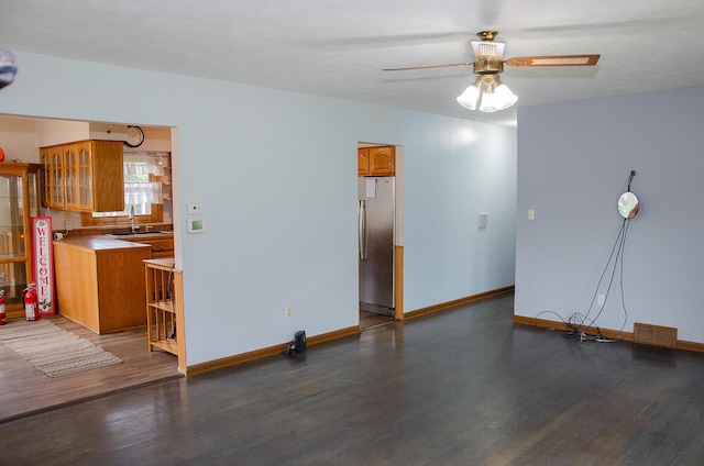 14888 E R Ave, Scotts, MI 49088 - unfurnished living room featuring wood finished floors, ceiling fan, baseboards, and a sink