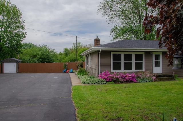 14888 E R Ave, Scotts, MI 49088 - view of front facade with a chimney, an outdoor structure, a garage, asphalt driveway, and a shingled roof
