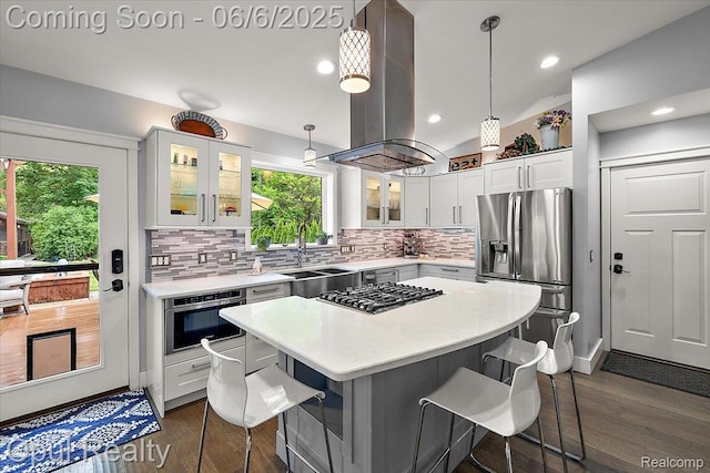 716 Magnolia Ave, Royal Oak, MI 48073 - kitchen featuring a sink, island exhaust hood, stainless steel appliances, a kitchen bar, and dark wood-type flooring