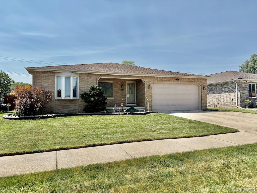 7411 N Farmington Rd, Westland, MI 48185 - ranch-style home with brick siding, a garage, driveway, and a front lawn