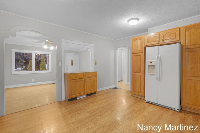 853 California St NW, Grand Rapids, MI 49504 - kitchen with white refrigerator with ice dispenser, ornamental molding, a ceiling fan, light wood-type flooring, and baseboards