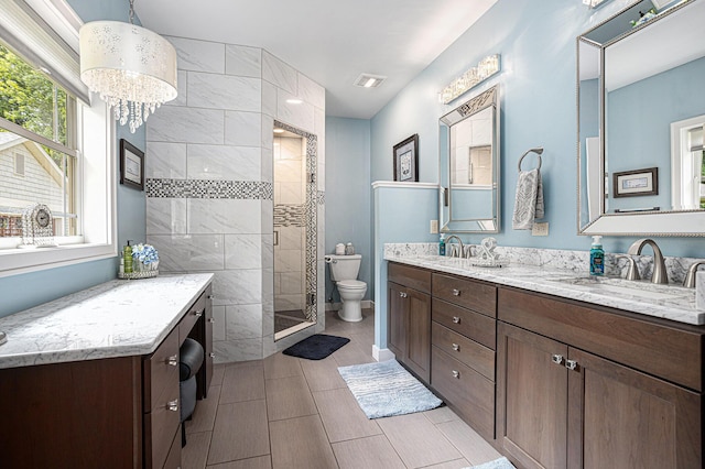 33515 28th Ave, Paw Paw, MI 49079 - full bathroom with double vanity, toilet, a shower stall, and a chandelier