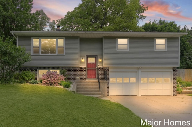 1724 Sandra St NW, Grand Rapids, MI 49544 - split foyer home with a garage, concrete driveway, and brick siding