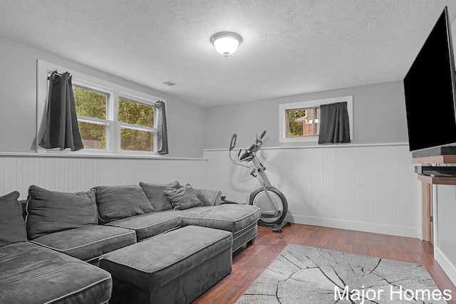 1724 Sandra St NW, Grand Rapids, MI 49544 - living area with wainscoting, a textured ceiling, healthy amount of natural light, wood finished floors, and baseboards