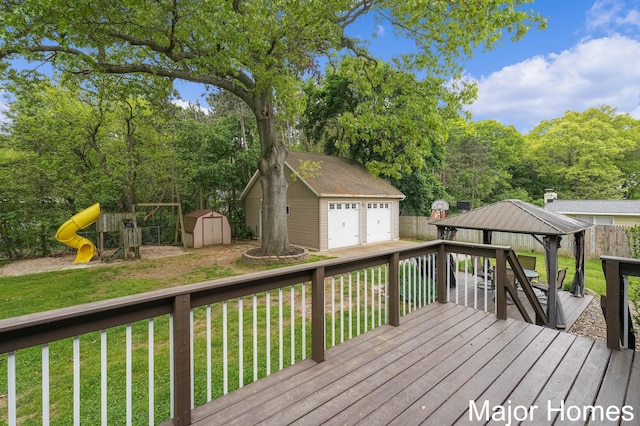 1724 Sandra St NW, Grand Rapids, MI 49544 - wooden deck featuring a detached garage, a gazebo, and a playground