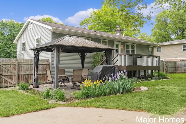 1724 Sandra St NW, Grand Rapids, MI 49544 - rear view of house featuring a gazebo, a chimney, a patio, a wooden deck, and roof with shingles