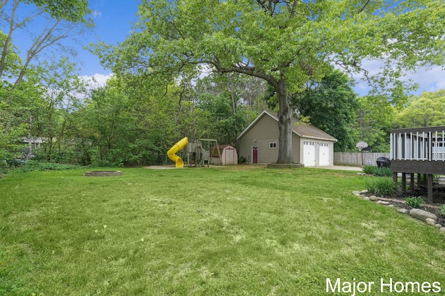 1724 Sandra St NW, Grand Rapids, MI 49544 - view of yard featuring a garage, a playground, and view of wooded area