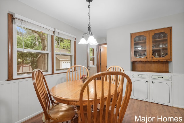 1724 Sandra St NW, Grand Rapids, MI 49544 - dining room featuring light wood-type flooring, a chandelier, and a decorative wall