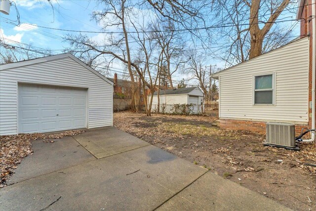 17217 Plainview Ave, Detroit, MI 48219 - view of yard with concrete driveway, central air condition unit, an outdoor structure, and a detached garage