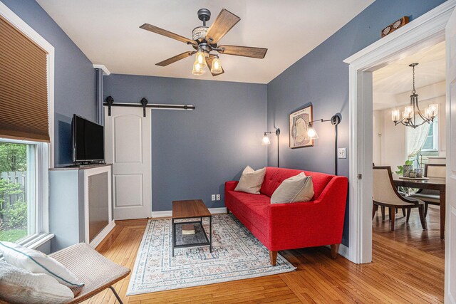 2335 Niles Ave, Saint Joseph, MI 49085 - living room with a chandelier, a barn door, light wood finished floors, and a ceiling fan