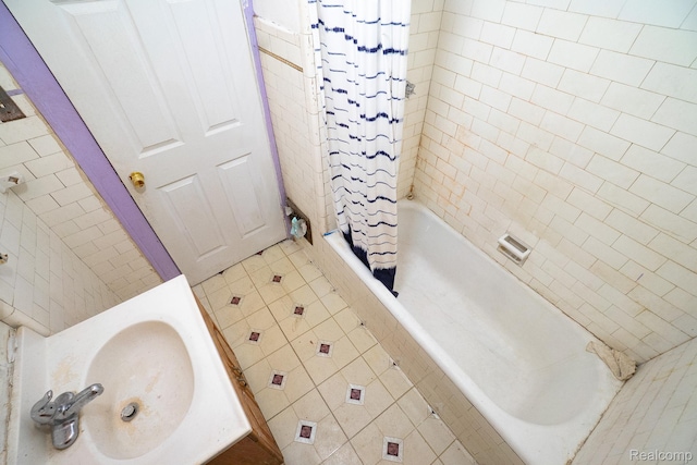12151 Corbett St, Detroit, MI 48213 - full bath featuring tiled shower / bath combo, a sink, tile patterned flooring, and tile walls