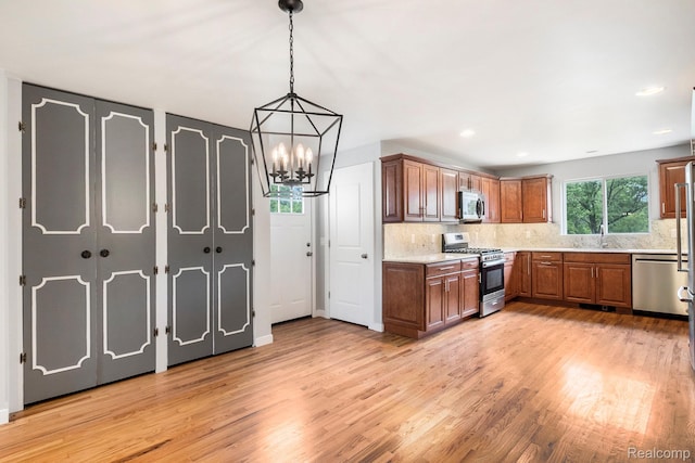 7340 Hartland Rd, Fenton, MI 48430 - kitchen with stainless steel appliances, a sink, light wood-style flooring, tasteful backsplash, and recessed lighting