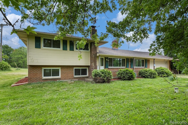 7340 Hartland Rd, Fenton, MI 48430 - split level home featuring a chimney, a front lawn, brick siding, and a porch