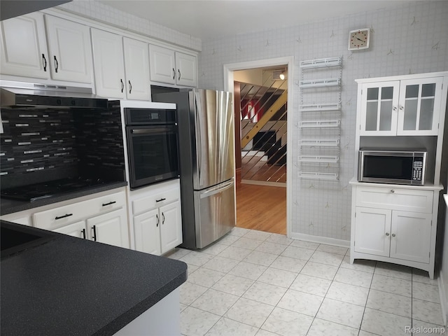 24781 Larkins St, Southfield, MI 48033 - kitchen featuring black appliances, wallpapered walls, under cabinet range hood, white cabinets, and dark countertops