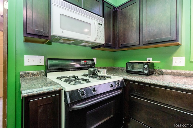 28399 Felician St, Roseville, MI 48066 - kitchen with gas range, white microwave, and dark brown cabinetry
