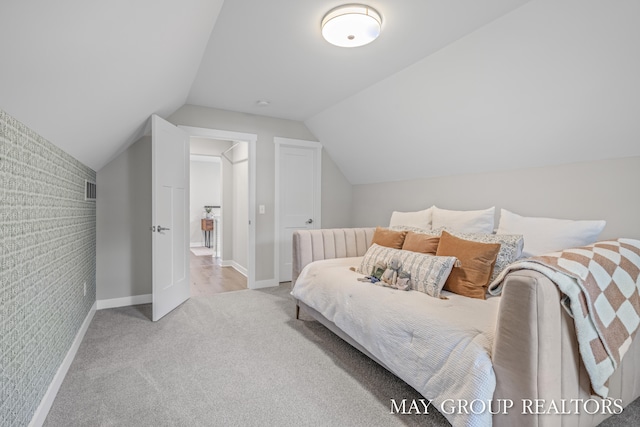 2050 Anderson Dr SE, East Grand Rapids, MI 49506 - carpeted bedroom with baseboards, vaulted ceiling, and an accent wall