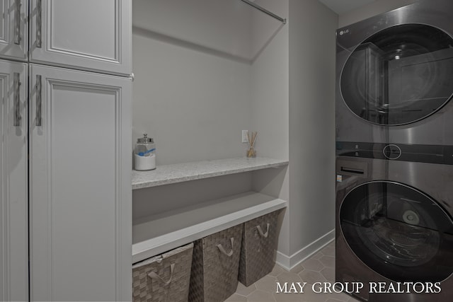 2050 Anderson Dr SE, East Grand Rapids, MI 49506 - laundry room with estacked washer and dryer, cabinet space, and tile patterned floors