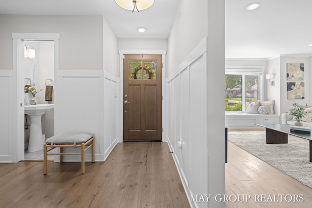 2050 Anderson Dr SE, East Grand Rapids, MI 49506 - foyer entrance with light wood-style floors, healthy amount of natural light, a wainscoted wall, and a decorative wall