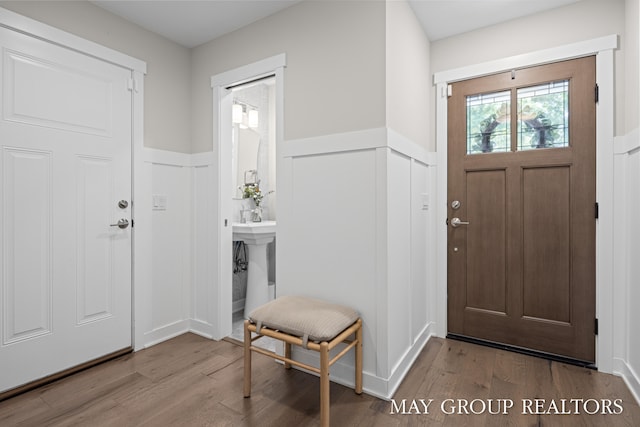 2050 Anderson Dr SE, East Grand Rapids, MI 49506 - entrance foyer featuring a wainscoted wall, wood finished floors, and a decorative wall