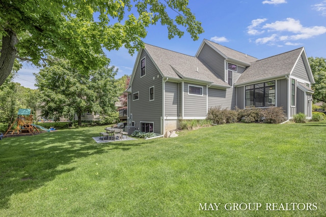 2050 Anderson Dr SE, East Grand Rapids, MI 49506 - view of property exterior with a yard, a patio, a shingled roof, central air condition unit, and a playground