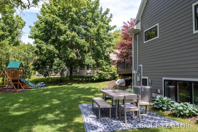 2050 Anderson Dr SE, East Grand Rapids, MI 49506 - view of green lawn with cooling unit, outdoor dining space, and a playground