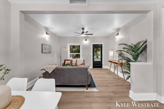810 James St, Belding, MI 48809 - living room with light wood-type flooring, a ceiling fan, and baseboards