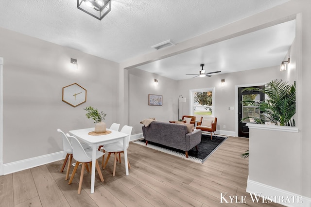810 James St, Belding, MI 48809 - dining room featuring light wood-style flooring, baseboards, a textured ceiling, and a ceiling fan