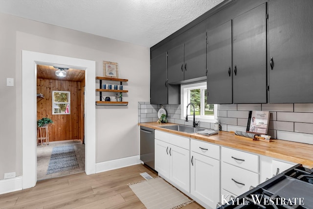 810 James St, Belding, MI 48809 - kitchen with a sink, dishwasher, butcher block countertops, baseboards, and wood walls