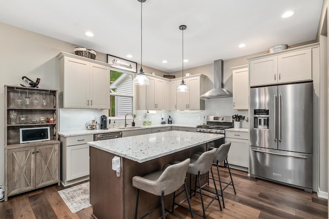 10321 E C Ave, Richland, MI 49083 - kitchen with appliances with stainless steel finishes, wall chimney range hood, a kitchen island, dark wood-type flooring, and a sink