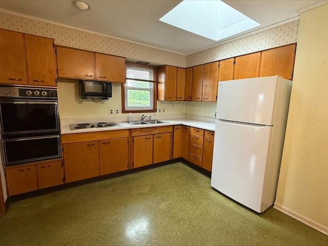 538 Wharton Ave, Ypsilanti, MI 48198 - kitchen with freestanding refrigerator, a sink, electric stovetop, a skylight, and wallpapered walls