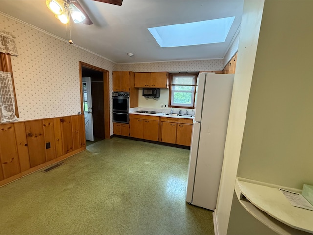 538 Wharton Ave, Ypsilanti, MI 48198 - kitchen featuring black appliances, brown cabinetry, a wainscoted wall, light countertops, and a sink