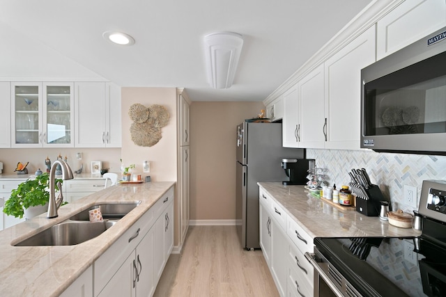 824 Cliffs Dr E Unit 304, Ypsilanti, MI 48198 - kitchen with appliances with stainless steel finishes, a sink, white cabinets, light stone counters, and light wood-style flooring
