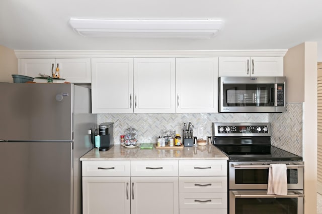 824 Cliffs Dr E Unit 304, Ypsilanti, MI 48198 - kitchen with appliances with stainless steel finishes, white cabinets, decorative backsplash, and light stone counters